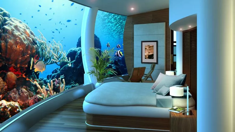Suite sous-marine luxueuse avec vue panoramique sur un récif corallien coloré, poissons tropicaux et faune marine exotique, offrant une expérience immersive unique.